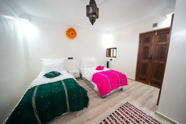 Chambre lits jumeaux et sa porte en bois sculpté